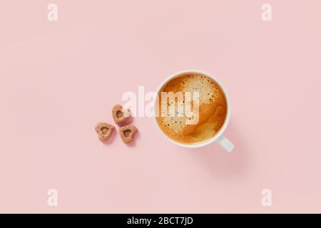 Morgenbecher mit kräftigem Kaffee und drei Stück Zucker in Form von Herzen. Stockfoto