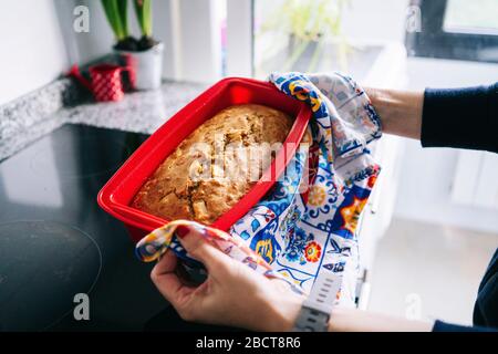 Eine Frau legt einen Kuchen in den Ofen Stockfoto