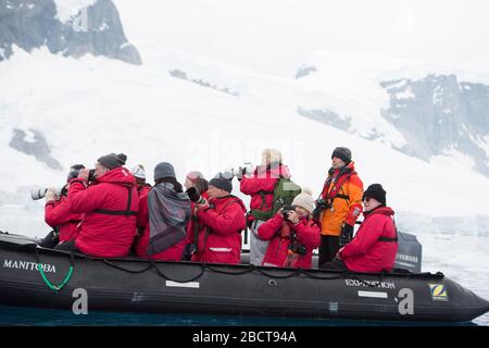 Touristen in einem Schlauchboot mit Tierkreis vor der Insel Danco in der Antarktis Stockfoto