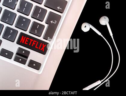 Brüssel, Belgien - 4. April 2020: Netflix-Logo auf einer Laptop-Tastatur mit Headset. Stockfoto
