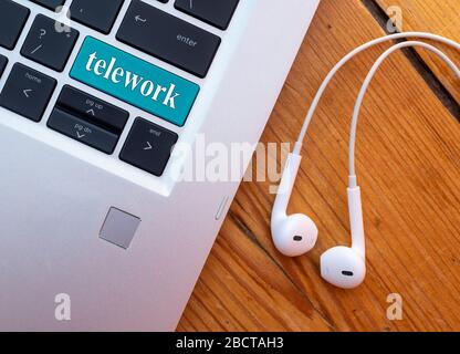 Telearbeit-Konzept. Laptop mit Headset und Wort-Telearbeit auf der Tastatur. Stockfoto