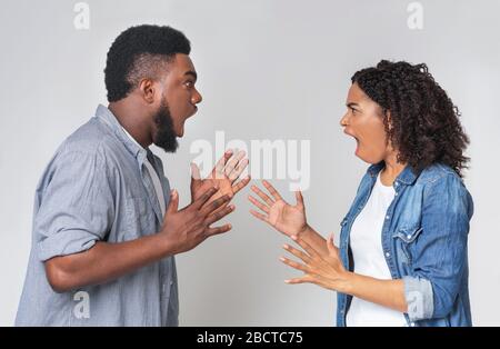 Paare Streiten. Wütende Schwarze Männer Und Frauen Schreien Einander An Stockfoto