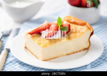 Kasserolenscheibe aus Käse mit Creme und frischen Erdbeeren. Russisches Frühstück, halbsüßer Käsekuchen mit Eiweiß und Kalzium, z. Stockfoto