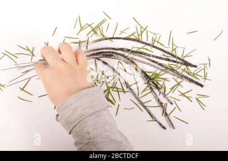 Kind Hand hält verbrannte Silvester-Wunderkerzen und eine Menge von Spitzen von Weihnachtsbaum Stockfoto