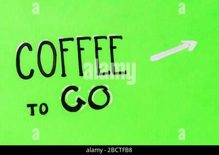 Motivations Slogan Kaffee mit weißem Pfeil Zeiger auf einem hölzernen grünen Hintergrund gehen. Die Inschrift ist in caligraphic Handschrift gemacht. Hintergrund Stockfoto