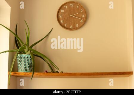 Nahansicht einer Uhr an der Wand mit einer Anlage im ersten Regal Stockfoto