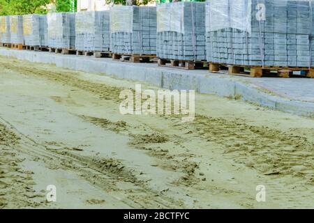 Straßenarbeiten auf der Verlegung von Pflasterplatten mit der Verlegung von Sand Stockfoto