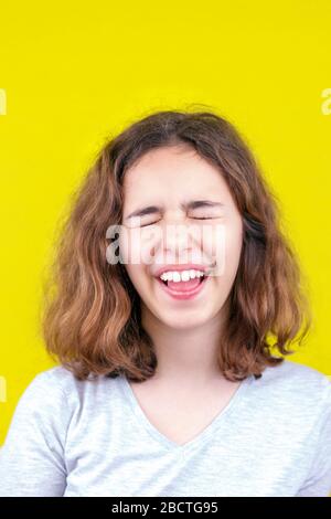 Süßes lockiges Teenager-Mädchen mit einem lustigen Gesicht. Stockfoto