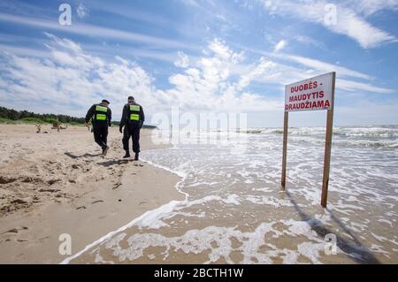 Badeverbotsschild in der leeren Palanga Strand, die Verbotsworte in litauischer Sprache geschrieben. Stockfoto