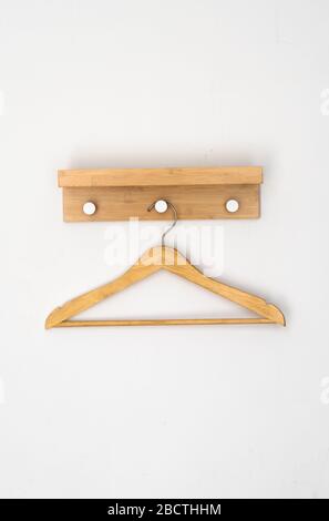 Kleiderbügel aus Holz an einer weißen Wand. Stockfoto