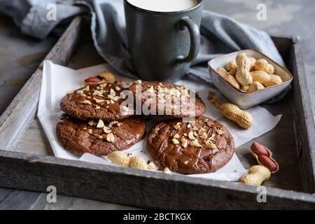 Köstliche Brownie-Plätzchen mit geschmolzener Schokolade und gehackten Erdnüssen Stockfoto