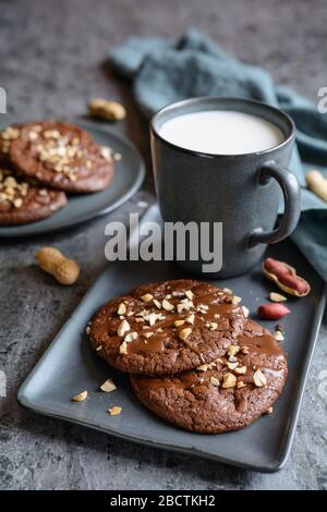 Köstliche Brownie-Plätzchen mit geschmolzener Schokolade und gehackten Erdnüssen Stockfoto