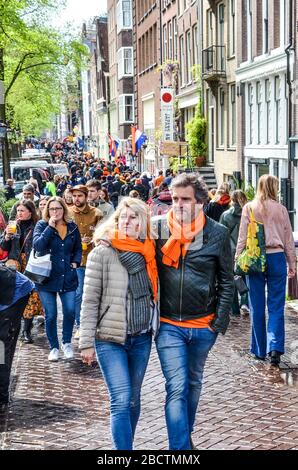 Amsterdam, Niederlande - 27. April 2019: Menschen auf der Straße, die orangefarbene Accessoires tragen, die den Kings Day, Koningsdag, den Geburtstag des niederländischen Königs Willem-Alexander feiern. Überfüllte Straßen. Stockfoto