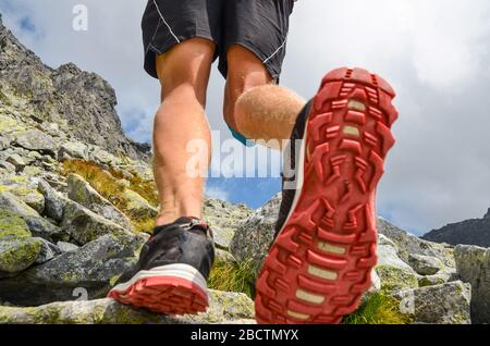 Die Beine des Touristen in den Bergen. Sport aktives Foto. Stockfoto