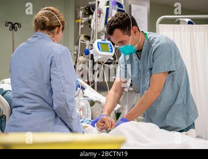 U.S. Navy LT. Wade Miller behandelt einen Patienten an Bord des Hospitalschiffs USNS Mercy, das zur Unterstützung der COVID-19, Coronavirus Pandemie, 4. April 2020 in Los Angeles, Kalifornien, eingesetzt wird. Stockfoto