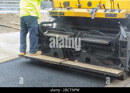 Asphalt fertiger Maschine beim Straßenbau, Verkehrswegebau die erste Schicht der Asphalt. Stockfoto