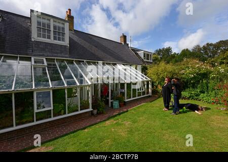 Blick auf Monk's House, einst das Zuhause von Virginia Woolf, Rodmell, East Sussex, Großbritannien, aus dem Garten, mit prominenten Holz-und Glas-Wintergarten. Stockfoto