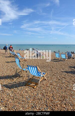 Liegestühle am Strand von Brighton, UK Stockfoto