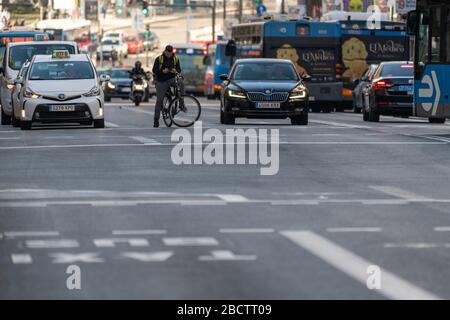 MADRID, SPANIEN - 24. FEBRUAR 2019: Stadtbusse, Autos, Fahrräder und Motorräder warten an einer Ampel in der belebten Gran Via Straße in Madrid, einer von t Stockfoto