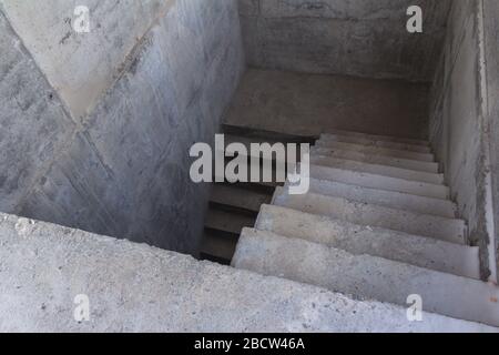 Eine Leiter aus Beton, die nach unten führt. Konkrete Schritte. Treppen runter Stockfoto