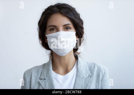 Porträt der jungen schönen Frau, die eine Atemschutzmaske trägt. Stockfoto