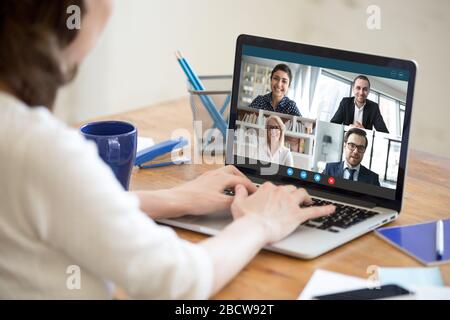 Frau, die von zu Hause aus an einem Gruppenvideoanruf teilnimmt Stockfoto