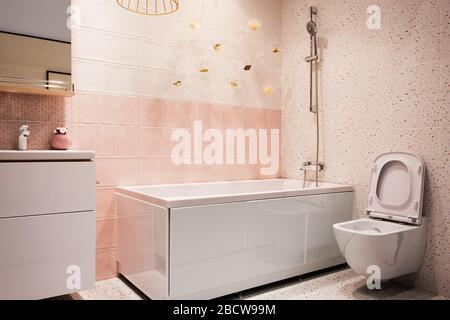 Weiß und pinkfarben modernes Badezimmer mit hänge-wc, Waschbecken, Badewanne, Wasserhahn, Spiegel, Dusche, Möbel und Accessoires. Stockfoto