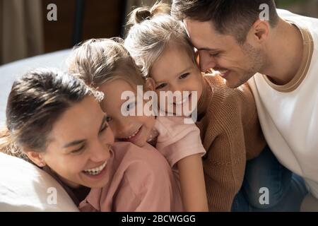 Liebevolle vierköpfige Familie, die einen süßen, zärtlichen Wochenend-Moment genießt. Stockfoto