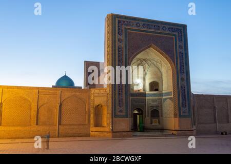 Fassade der Kalan-Moschee am Po-i-Kalan Religiösen Komplex in Buchara, Usbekistan während der blauen Stunde. Moschee iwan dekoriert im POI Kalan. Kalon Moschee. Stockfoto