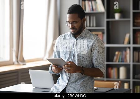 Afroamerikanischer Mann surft auf Tablet im Internet Stockfoto