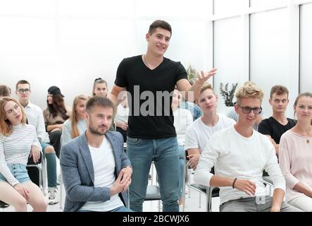 Der junge Mann stellt während eines Vortrags Fragen. Stockfoto