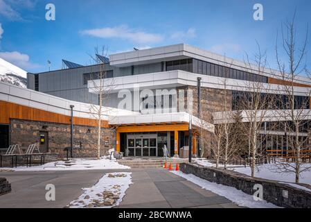 Canmore, Alberta - 4. April 2020: Blick auf die Außenfassade des Elevation Place, Canmore's Erholungszentrum, an einem schönen Wintertag. Stockfoto