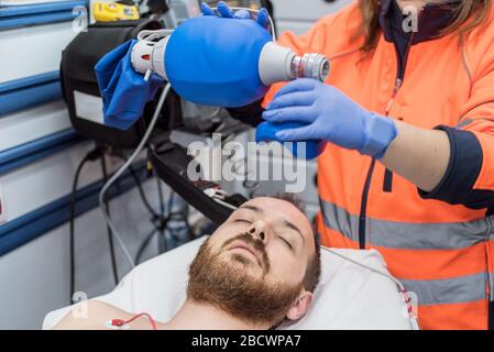 Covid-19 Atemnot. Notarzt, der eine Maske für Ambu-Beutel bei einem Patienten mit Lungenentzündung aufgrund einer Coronavirus-Infektion zur künstlichen Beatmung verwendet. Stockfoto