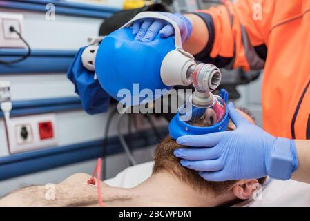 Covid-19 Atemnot. Notarzt, der eine Maske für Ambu-Beutel bei einem Patienten mit Lungenentzündung aufgrund einer Coronavirus-Infektion zur künstlichen Beatmung verwendet. Stockfoto