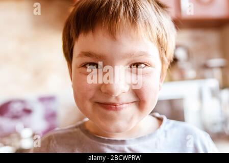 Portrait von verspielten laughting kleiner Junge innerhalb des Hauses in der Küche Stockfoto