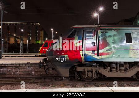 LNER GEC-Klasse 91 Elektrolokomotive 91111 für die Gefallenen und eine DB Cargo Klasse 90 beide arbeitende LNER-Züge im Bahnhof London Kings Cross Stockfoto