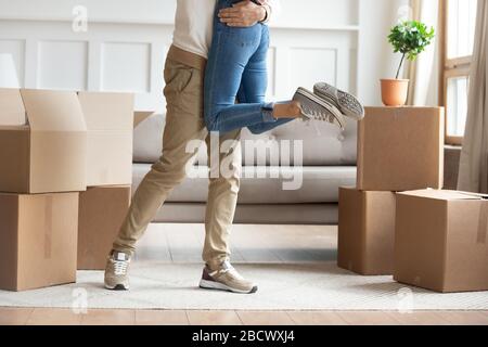 Zugeschnittenes Bild junger Mann, der die umarmende Frau hebt. Stockfoto