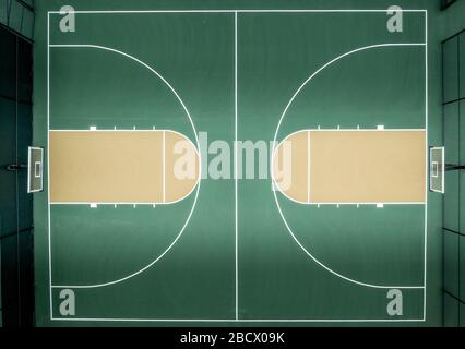 Luftbild von oben nach unten zum Mehrsport-Basketballplatz in der Nachbarschaft mit grünem Straßenbelag Stockfoto