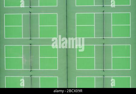 Von oben aus gesehen, von oben gesehen, das gemeinschaftliche Sportzentrum, grüne Tennis-Badmintonplätze Stockfoto