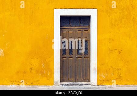 Gelbe Wandfassade und Tür im Stadtzentrum von Izamal, Yucatan-Halbinsel, Mexiko. Stockfoto