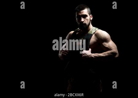 Bodybuilder Porträt des Soldaten mit Bulletproof West und US Flag auf schwarzem Hintergrund Stockfoto