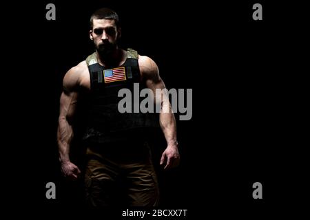 Bodybuilder Porträt des Soldaten mit Bulletproof West und US Flag auf schwarzem Hintergrund Stockfoto