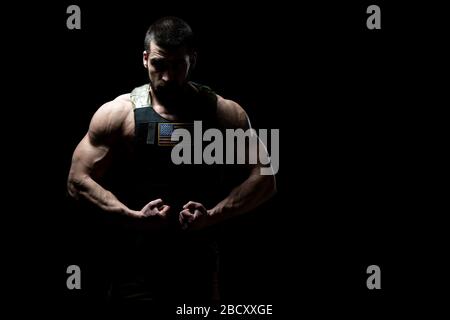 Bodybuilder Porträt des Soldaten mit Bulletproof West und US Flag auf schwarzem Hintergrund Stockfoto