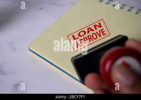 Roter Griff Gummistamper und Loan Aprroved Text isoliert auf weißem Hintergrund. Stockfoto