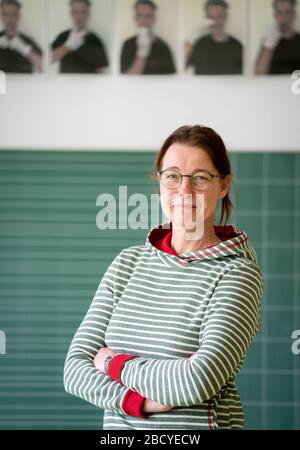 02. April 2020, Brandenburg, Oranienburg: Karin Bitter, Lehrerin an der Comenius-Grundschule in Oranienburg, blickt in die Kamera des Fotografen. Obwohl es derzeit keinen Unterricht in der Schule gibt, kommt Karin Bitter jeden Tag zu einer Videokonferenz mit ihren Schülern in ihr Klassenzimmer. Von den 22 Schülern ihrer dritten Klasse nehmen täglich etwa 12 Schüler an der Videokonferenz Teil, sagte die Lehrerin. Die Schüler nehmen das Angebot der Videokonferenz gerne an, um überhaupt miteinander in Kontakt zu bleiben. Im virtuellen Klassenzimmer wird kein neues Material gelehrt, sondern der aktuelle Ort Stockfoto