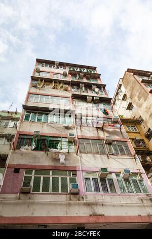 Altes, überfülltes und verfallenes Wohnhaus, typisch im Sham Shui Po in Hongkong, wo es historisch ärmere Einwanderer aus mA beherbergt Stockfoto