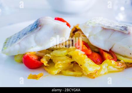 Gebackener Meeresbarsch mit gebratenem Gemüse und Kirschtomaten mit aromatischen Kräutern Stockfoto