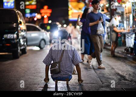 Bangkok, Thailand. April 2020. Ein behinderter Mann sitzt auf der Straße, während er in Bangkok um Geld bettelt. Credit: SOPA Images Limited/Alamy Live News Stockfoto