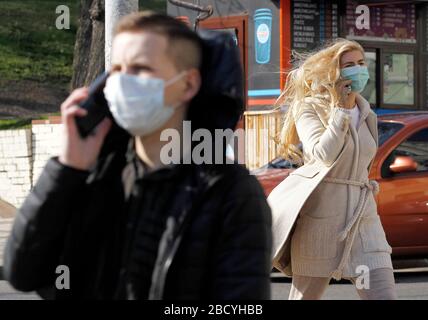 Kiew, Ukraine. April 2020. Menschen, die Gesichtsmasken als präventive Maßnahme gegen das COVID-19-Coronavirus tragen, sprechen auf Telefonen in der Innenstadt.die ukrainische Regierung hat ab dem 06. April 2020 neue verstärkte Quarantänemaßnahmen verabschiedet, um die Ausbreitung des Covid 19-Coronavirus einzudämmen, inmitten eines prognostizierten Höchsts, der in der Ukraine für den 14./15. April 2020 erwartet wird. Credit: SOPA Images Limited/Alamy Live News Stockfoto