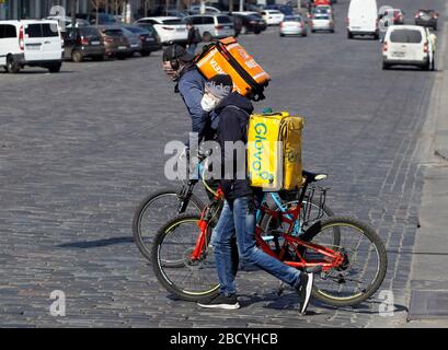 Kiew, Ukraine. April 2020. Kuriere, die Gesichtsmasken als präventive Maßnahme gegen das COVID-19-Coronavirus tragen, überqueren die Straße in der Innenstadt.die ukrainische Regierung hat ab dem 06. April 2020 neue verstärkte Quarantänemaßnahmen verabschiedet, um die Ausbreitung des Covid 19-Coronavirus einzudämmen, inmitten eines prognostizierten Höchsts, der in der Ukraine für den 14./15. April 2020 erwartet wird. Credit: SOPA Images Limited/Alamy Live News Stockfoto